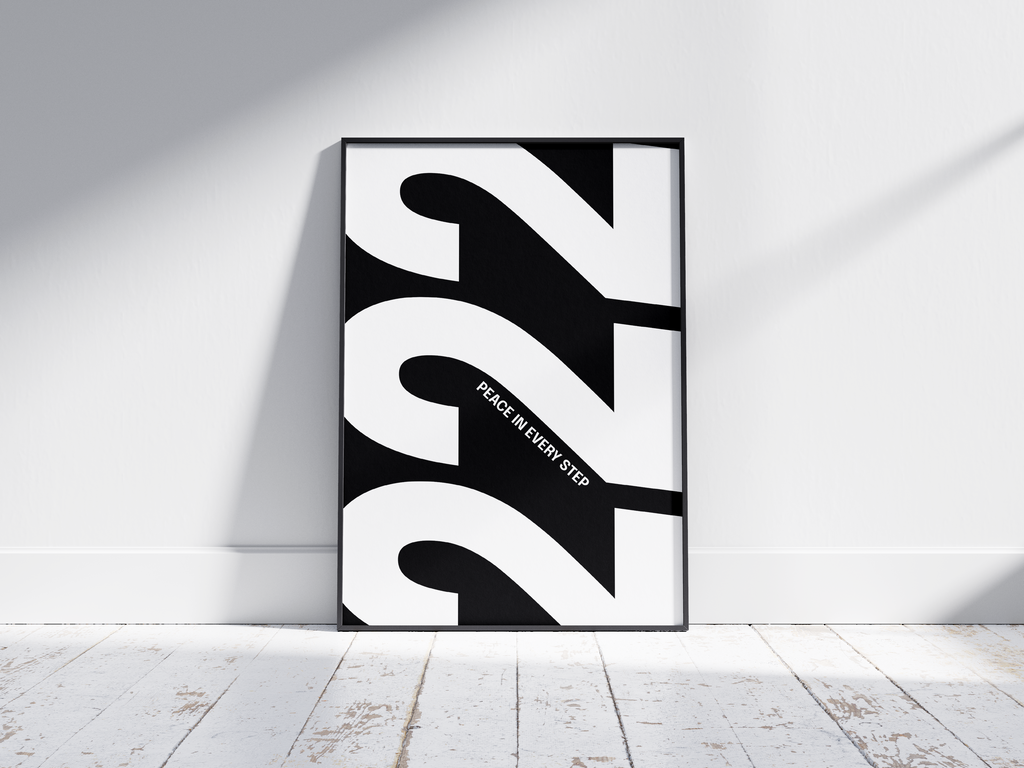 Minimalist black and white abstract poster featuring the repeated number 222 design and the quote "Peace in every step," framed and leaning against a white wall. Inspiring modern wall art for a peaceful, contemporary home or office interior.