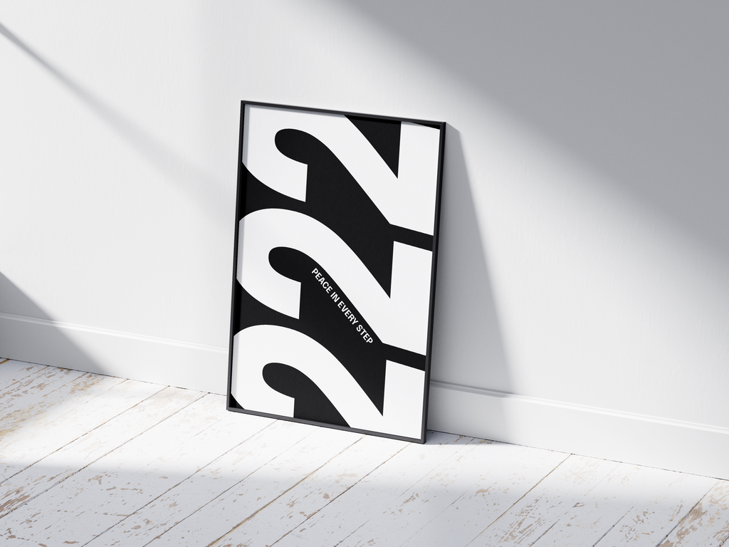 Minimalist black and white abstract poster featuring the repeated number 222 design and the quote "Peace in every step," framed and leaning against a white wall. Inspiring modern wall art for a peaceful, contemporary home or office interior.