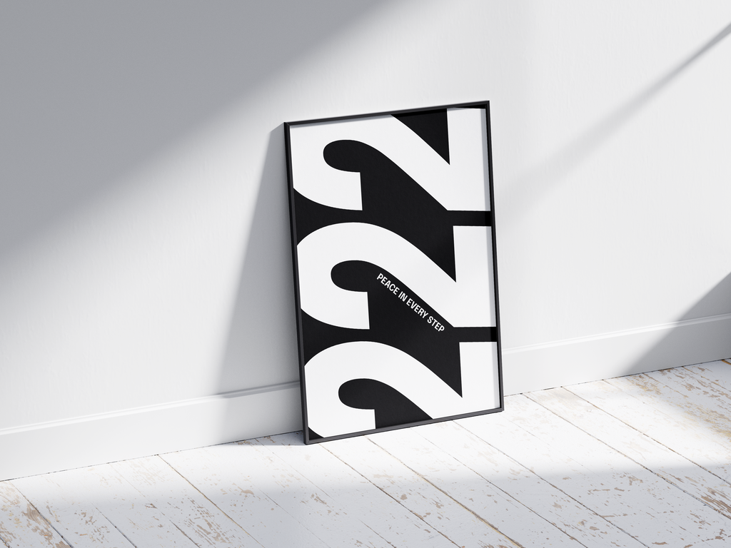 Minimalist black and white abstract poster featuring the repeated number 222 design and the quote "Peace in every step," framed and leaning against a white wall. Inspiring modern wall art for a peaceful, contemporary home or office interior.