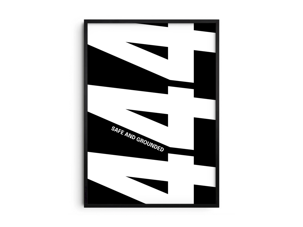 Minimalist black and white abstract poster featuring the repeated number 444 design and the quote "Safe and grounded," framed and leaning against a white wall. Inspiring modern wall art for a secure, contemporary home or office interior.