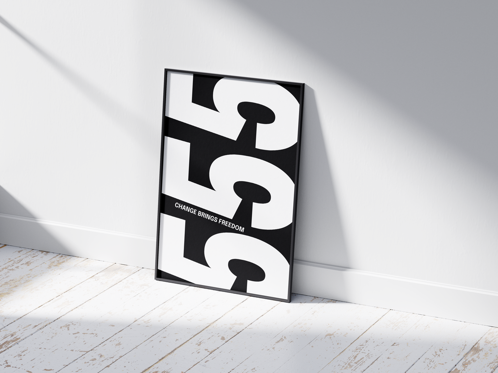 Minimalist black and white abstract poster featuring the repeated number 555 design and the quote "Change brings freedom," framed and leaning against a white wall. Inspiring modern wall art for a transitional, contemporary home or office interior.