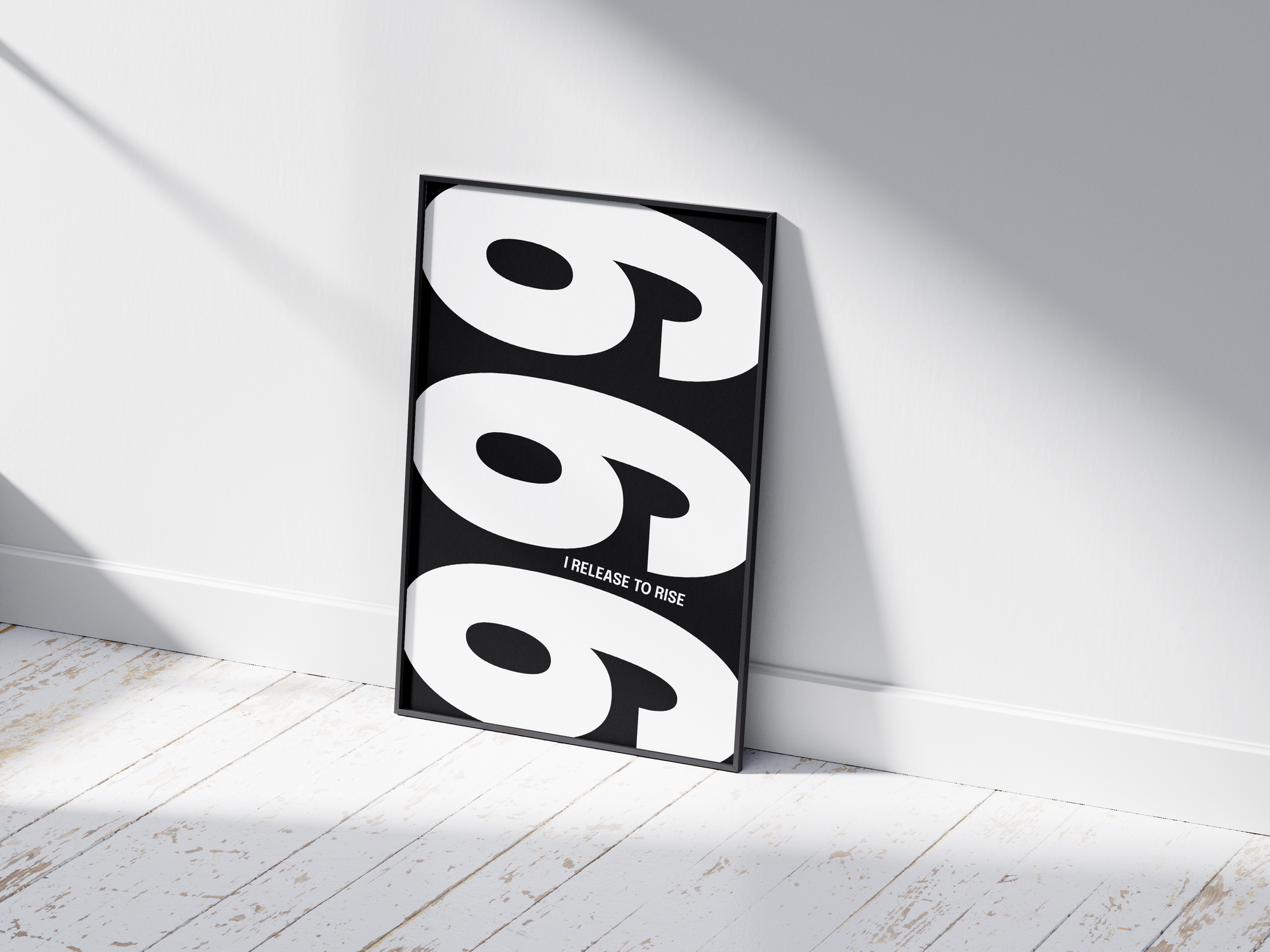 Minimalist black and white abstract poster featuring the repeated number 999 design and the quote "I release to rise," framed and leaning against a white wall. Inspiring modern wall art for a transformative, contemporary home or office interior.
