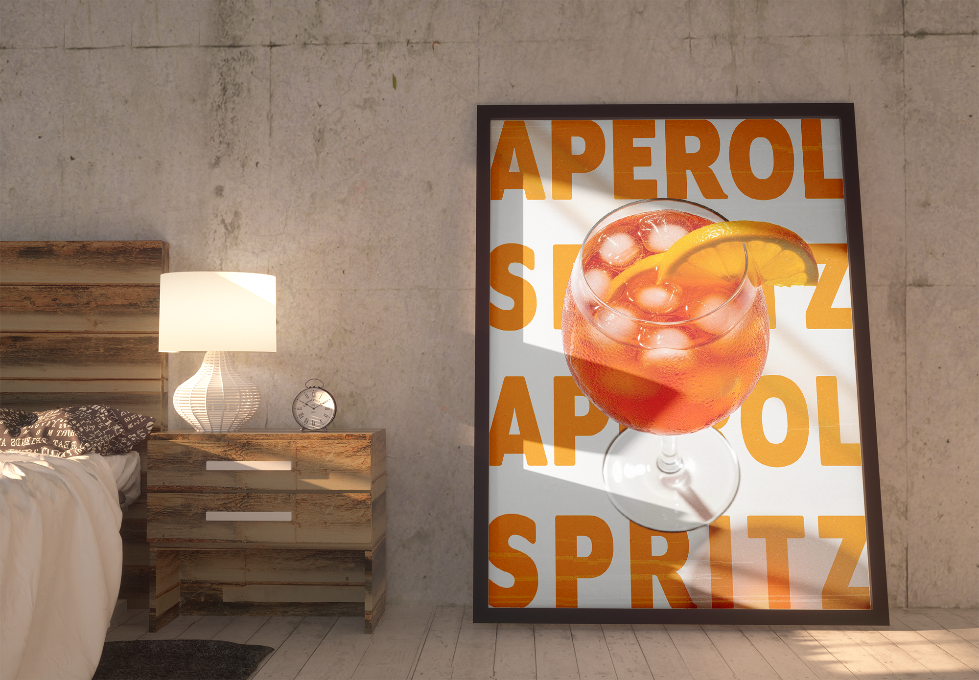 A large framed poster featuring a vibrant glass of Aperol Spritz with ice and an orange slice over a background with the repeated orange text "APEROL SPRITZ," leaning on the floor against a textured concrete-look wall next to a wooden bedside table and lamp.
