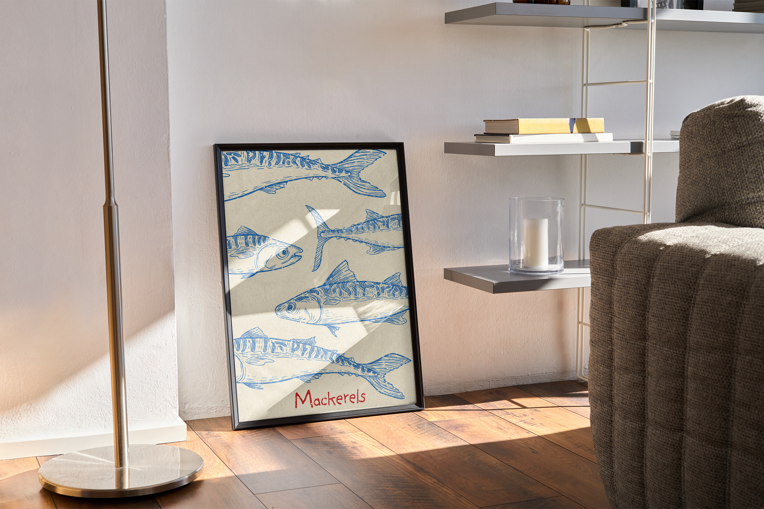 A black-framed print featuring multiple blue, stylized illustrations of mackerel fish on a neutral background with the word "Mackerels," leaning on a wooden floor in a minimalist living room next to a floor lamp and a gray shelving unit.