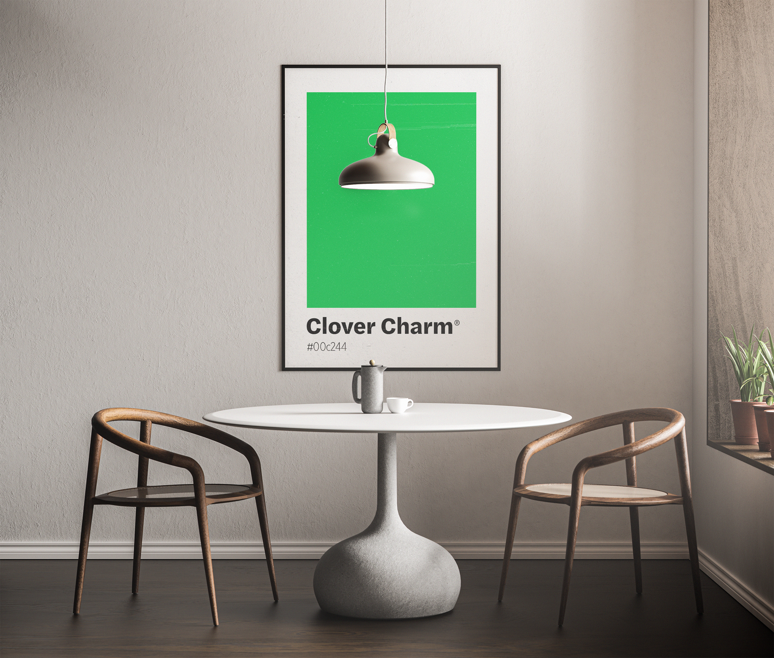 A black-framed poster featuring a large block of bright green labeled "Clover Charm," hanging above a round white table and two wooden chairs in a dining area.