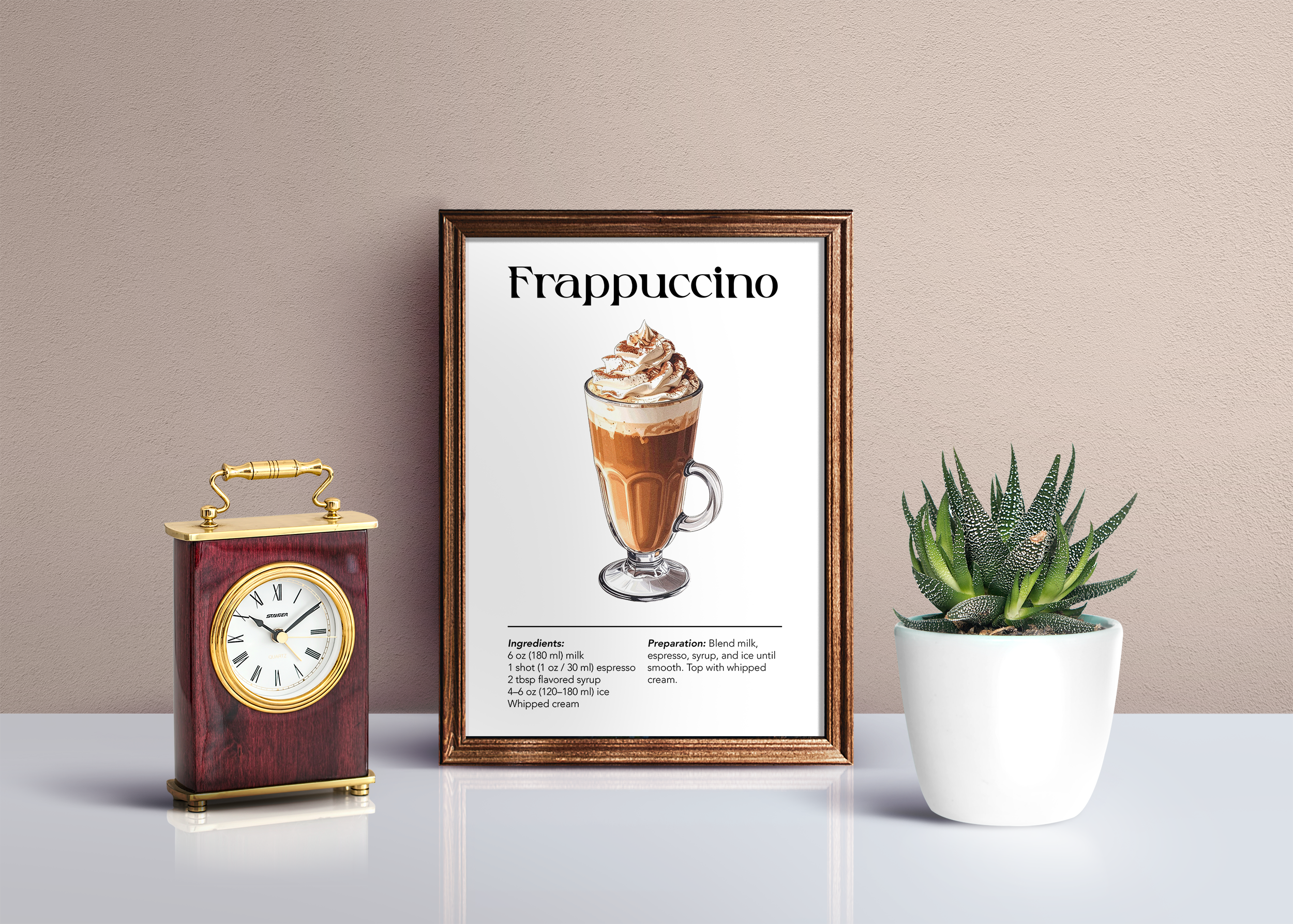 Small framed poster featuring an illustration of a Frappuccino with ingredients and preparation instructions, sitting on a white surface next to a gold and wood clock and a potted succulent.