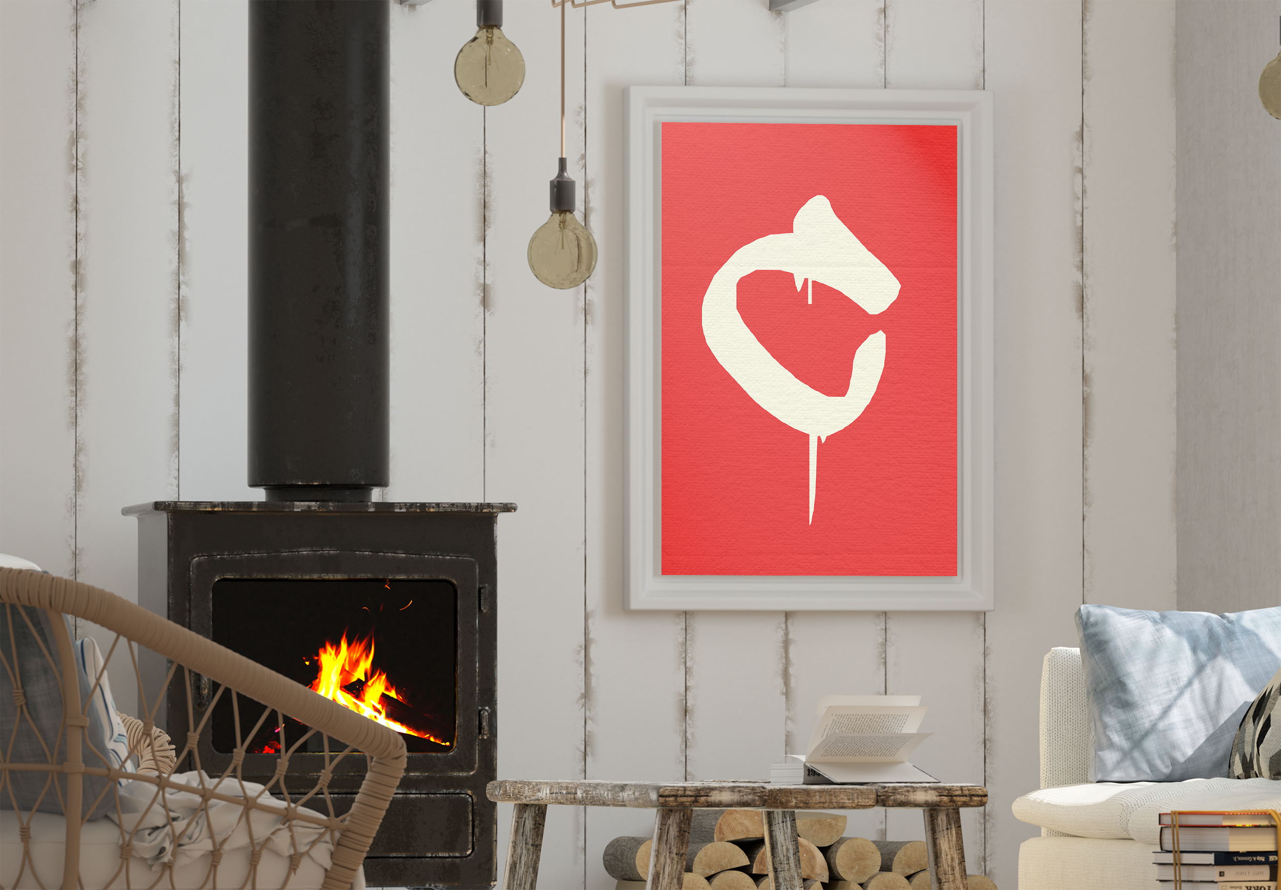 A framed white and red art print with a hand-painted/graffiti-style letter 'C', hanging in a cozy living room next to a black wood-burning stove with a fire visible.