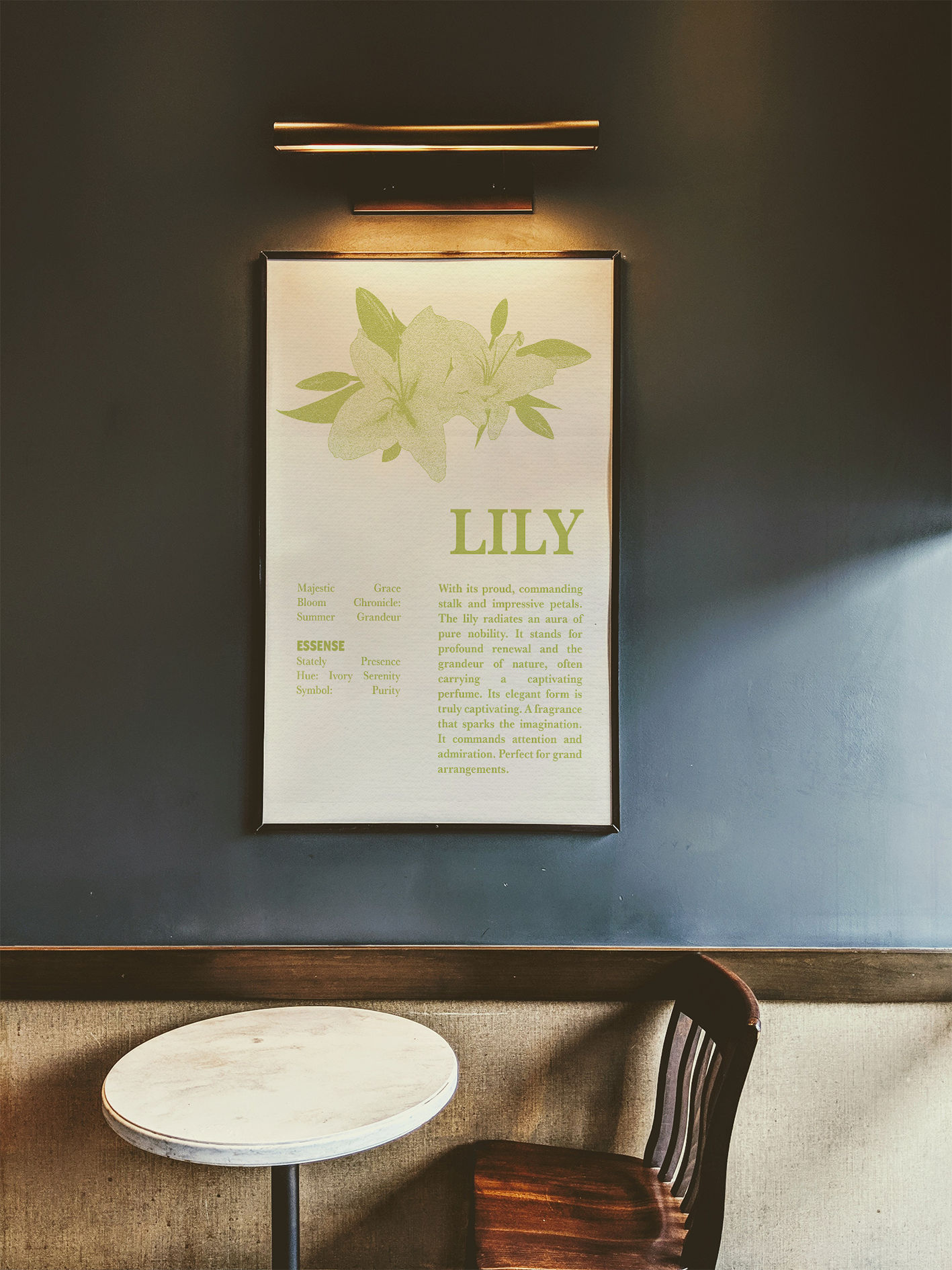 A framed poster hanging on a dark gray wall, featuring a dictionary-style definition of the word "LILY" and a light green, detailed illustration of the flower. Below the art, a small, modern round table with a wooden top and a simple dark wooden chair suggest a cafe or bistro setting.