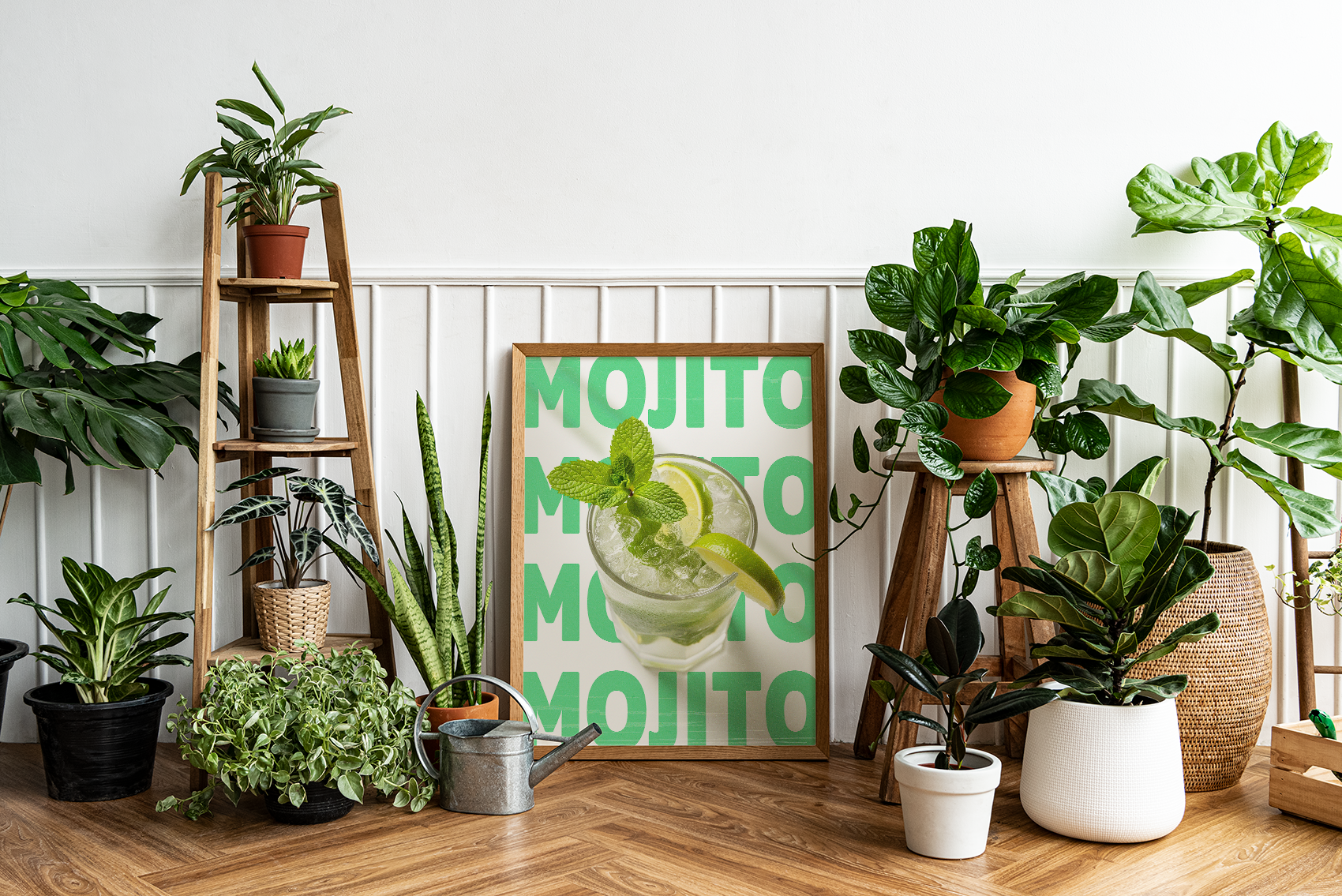 Framed poster of a Mojito cocktail with a lime and mint, set against a light green background with repeating 'MOJITO' text, surrounded by various houseplants and wooden furniture.