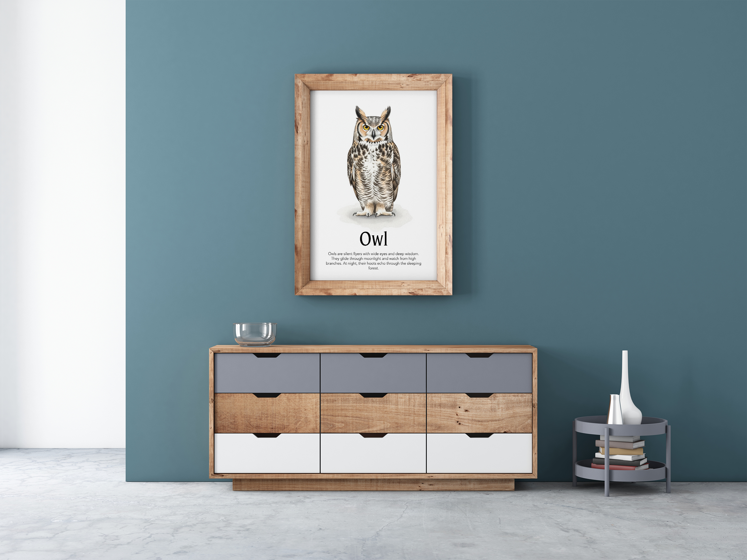 A framed poster with an Owl illustration with text, "Owl," hanging on a blue-grey wall above a modern wooden and grey dresser.
