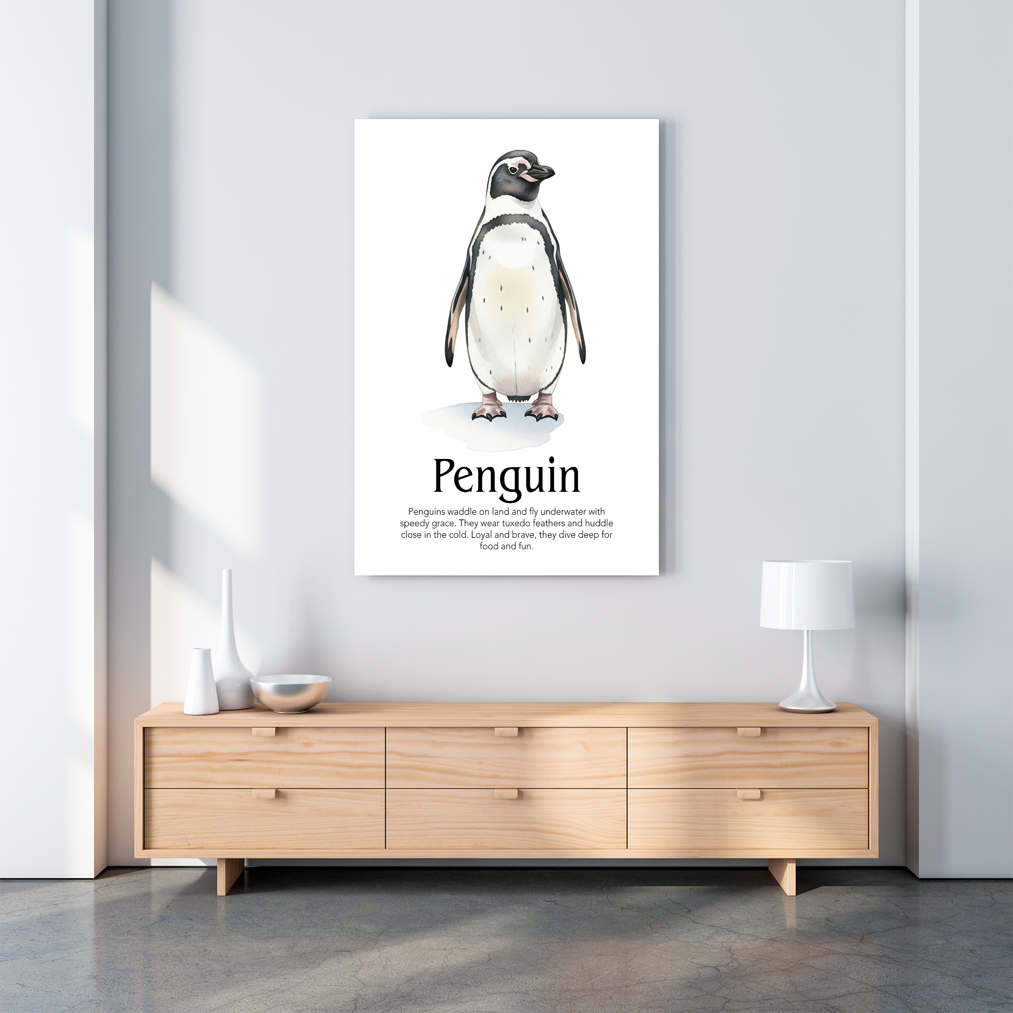 A vertical poster mockup featuring a watercolor illustration of a penguin with the title "Penguin" and a brief description, displayed unframed on a light gray wall above a light wood TV stand in a modern, brightly lit room.