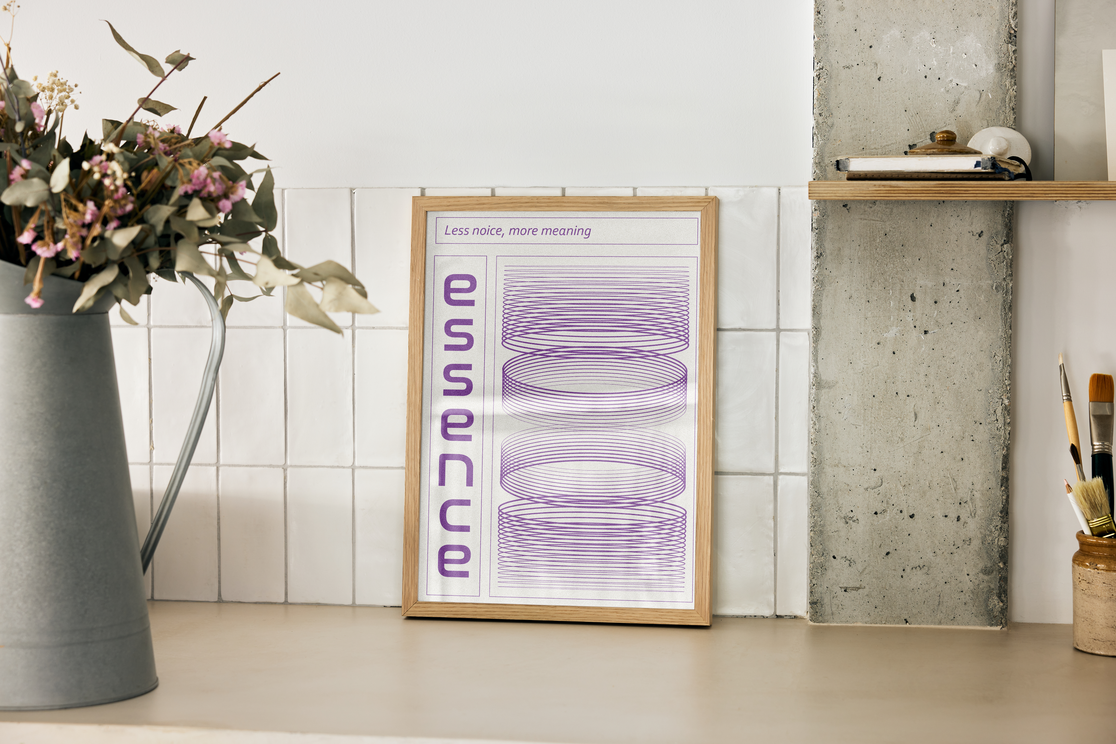 A wood-framed poster with purple, swirling wireframe rings and the text "essence," resting on a kitchen counter with white tiles and a concrete pillar.