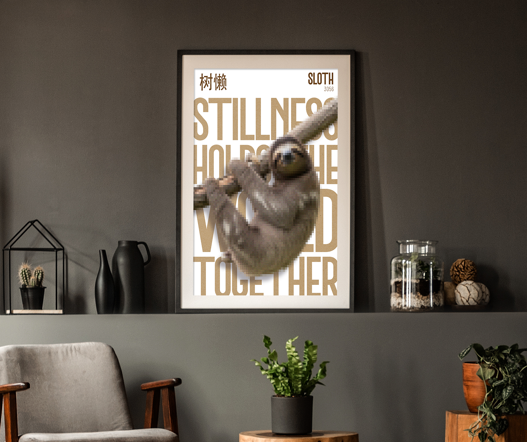 A framed poster of a Sloth hanging from a branch, illustrated with a pixelated effect, centered above a grey chair and a console shelf. The background text in a light brown color reads: "STILLNESS HOLDS THE WORLD TOGETHER." The wall is dark grey and decorated with small plants and black vases.