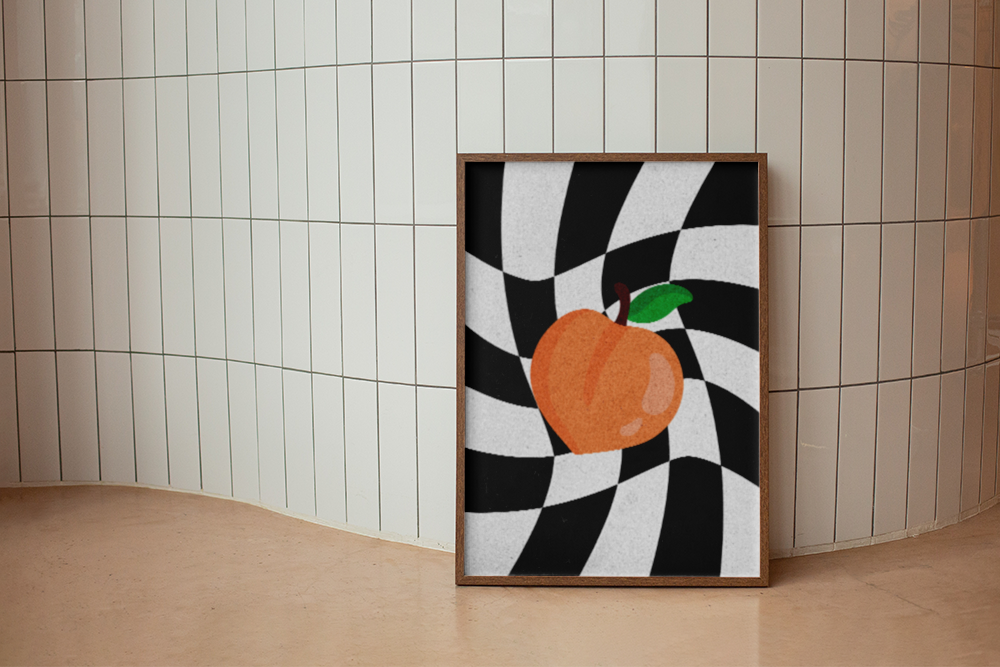 A playful and retro art print featuring a simple orange peach illustration centered over a dramatic, swirling black and white checkerboard background. Ideal for modern, retro, or eclectic spaces like kitchens, dining areas, or teens' rooms. The framed print is leaning against a curved white subway tile wall, creating a dynamic contrast.