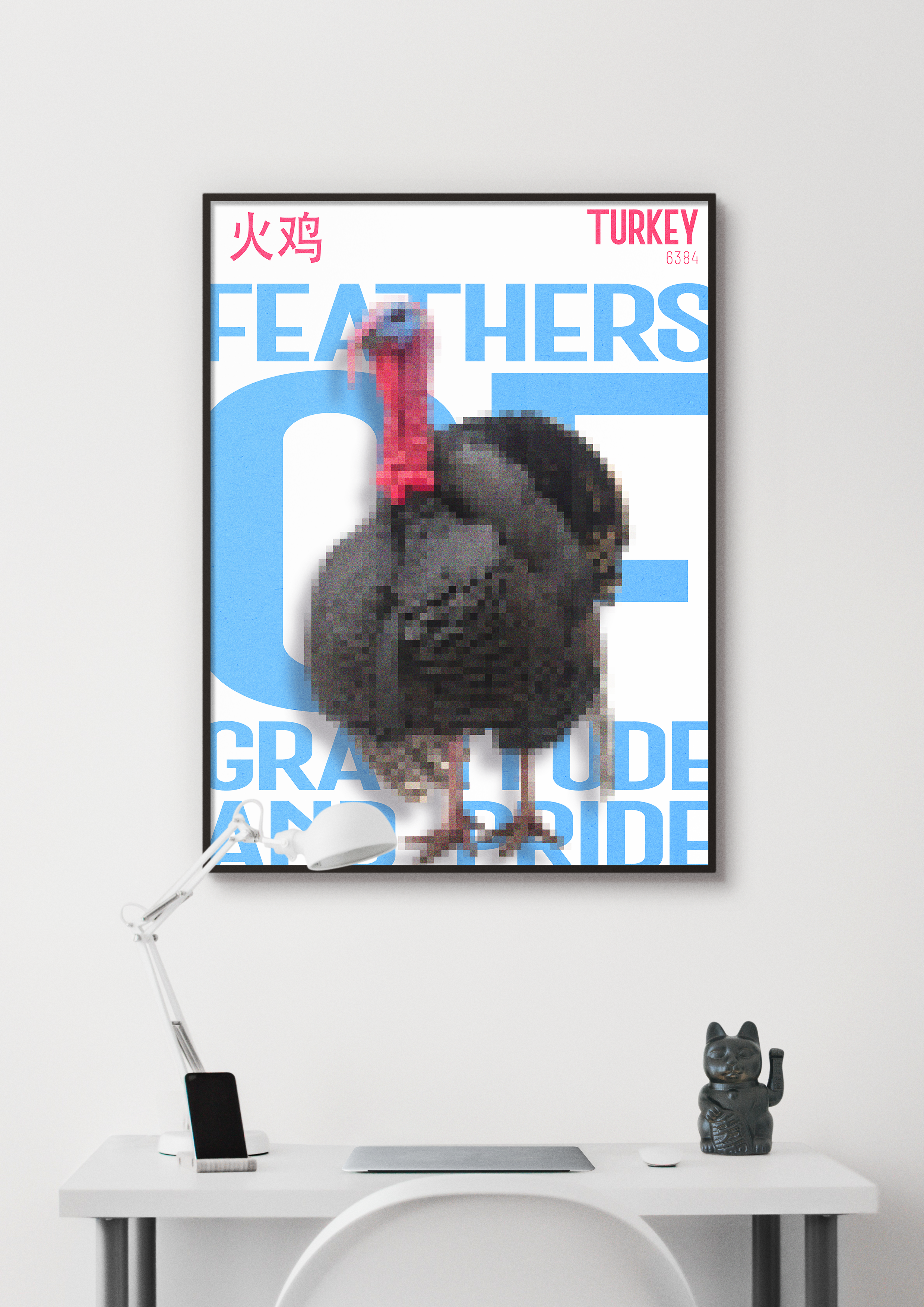 A framed poster featuring a stylized, pixelated image of a Turkey, against a background of large blue text that reads "FEATHERS OF GRATITUDE AND PRIDE." The poster is on a white wall above a clean, modern desk with a lamp and a Maneki-neko figurine.
