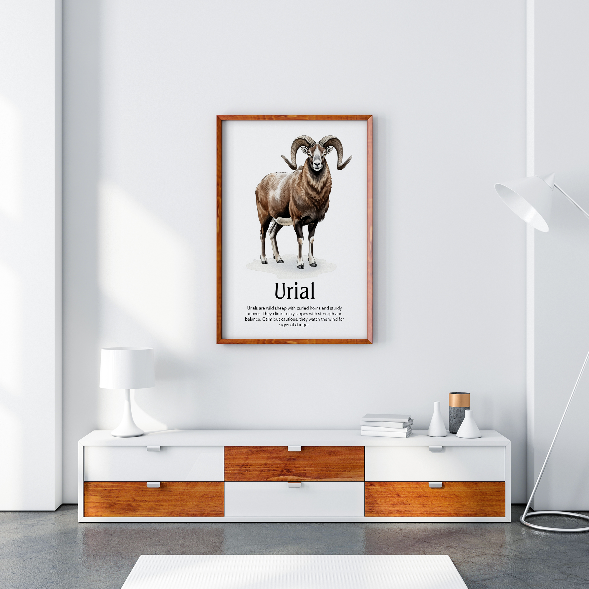 A framed vertical poster mockup featuring a watercolor illustration of a Urial with the title "Urial" and a brief description, displayed on a white wall above a white and brown TV stand. The frame is brown wood.