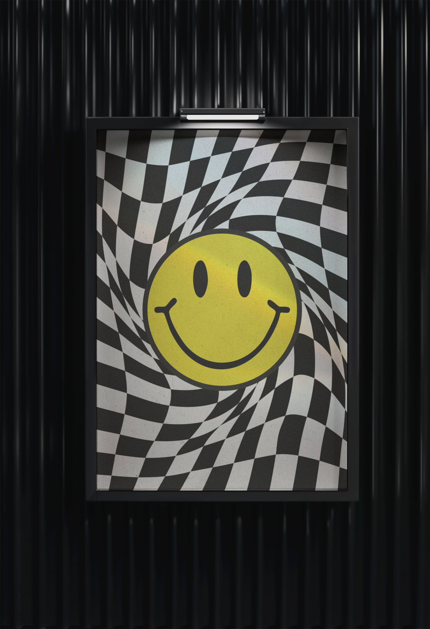 A framed poster featuring a psychedelic design with a yellow smiley face overlaying a black and white warped checkerboard pattern, hanging on a black, ribbed wall under a small spotlight.