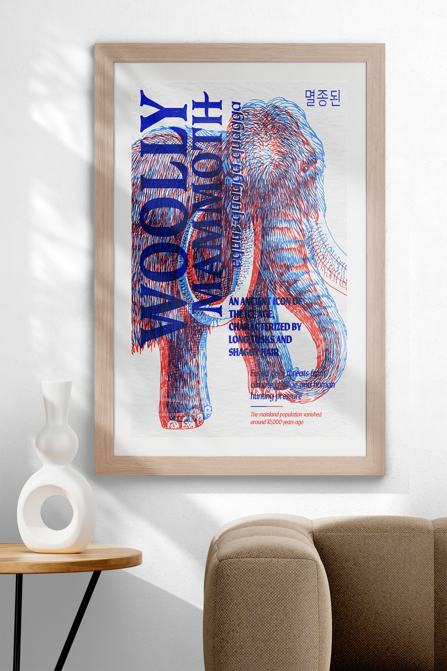 A vertically oriented, framed poster of a Woolly Mammoth, illustrated with an anaglyph effect of red and blue lines, hanging on a white wall above a modern white vase. The text describes it as "WOOLLY MAMMOTH" and "AN ANCIENT ICON OF THE ICE AGE."