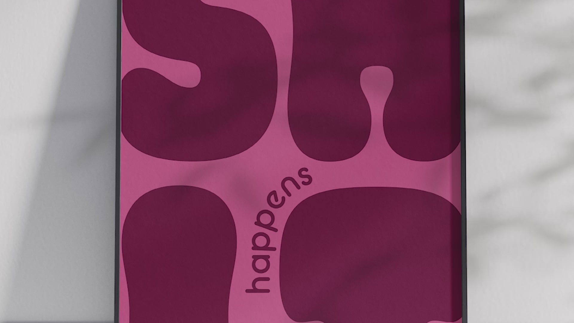 Bold "Shit Happens" modern art poster featuring large, wavy purple typography on a pink background, printed on semi-gloss sustainable paper. Perfect wall art for living rooms, offices, or contemporary interiors with a humorous and confident aesthetic.